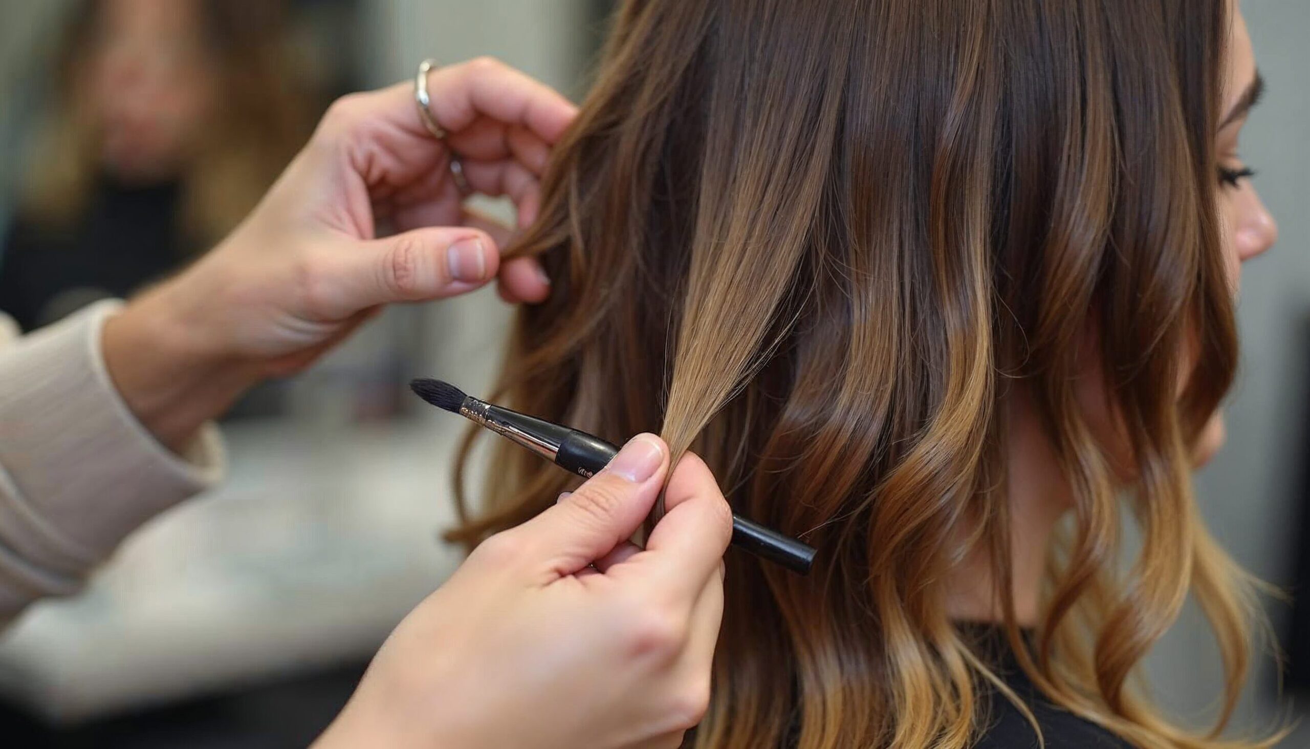 A woman receiving a haircut from a stylist at the best hair salon in Frisco, showcasing a professional grooming experience.