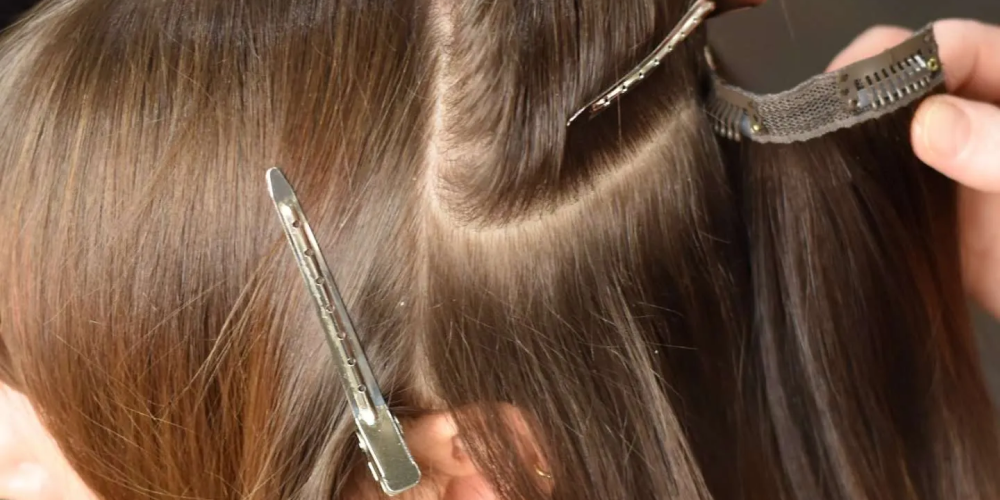 A beautiful woman with long wavy hair and striking green eyes, showcasing clip-in hair extensions in Dallas.